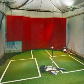 Inhägnad golfträningsyta med slagmatta, nät och golfutrustning