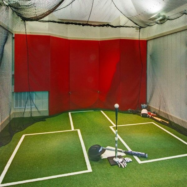 Inhägnad golfträningsyta med slagmatta, nät och golfutrustning