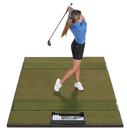 Golfspelare slår ut på en stor slagmatta inomhus